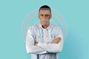 Angry sad serious displeased young african american man with crossed arms on chest