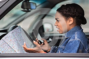 Angry saddened millennial african american female driver spreads arms to sides and not understanding how to find the way