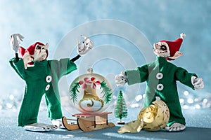 Angry Santas Helper Elf With Raised Hands Standing Next to Second Elf That Broke a Christmas Bauble. North Pole Christmas Scene.