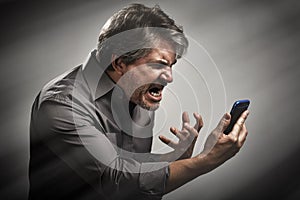 Angry screaming man with cell phone.