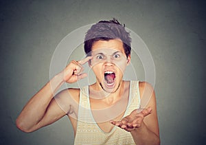 Angry screaming man gesturing with his finger are you crazy?