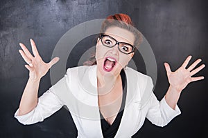 Angry screaming teacher on blackboard background