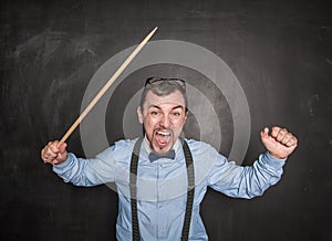 Angry screaming teacher with pointer on blackboard