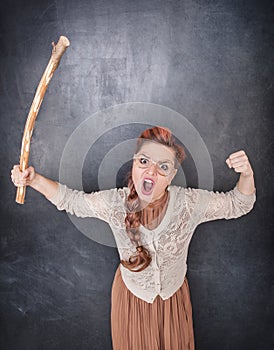 Angry screaming teacher with wooden stick