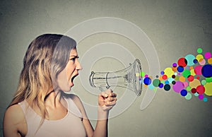 Angry screaming young woman holding megaphone