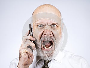 Angry senior businessman having a phone call