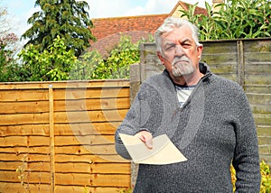 Angry Senior man giving a plain brown envelope.