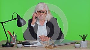 Angry senior old business woman making phone call at office work annoyed boss talking mobile quarrel