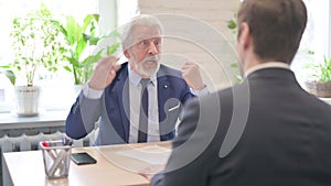 Angry Senior Old Businessman Talking with Businessman in Office, Shouting