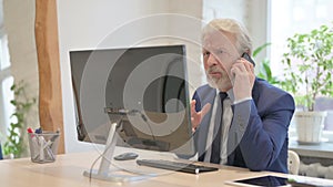 Angry Senior Old Businessman Talking on Phone at Work