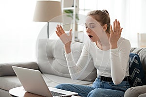 Angry shocked woman annoyed about computer problem on stuck laptop