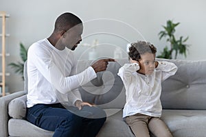 Angry single black father scolding stubborn fussy little african son