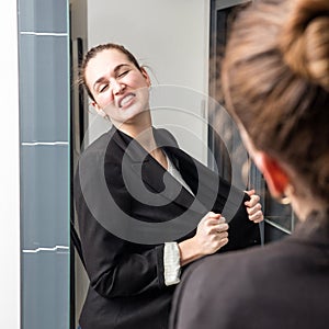 Angry smart young woman losing temper in front of her mirror