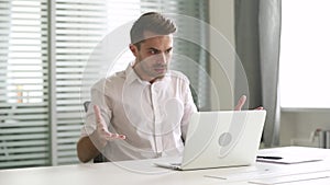 Angry stressed businessman looking at laptop having problem with computer