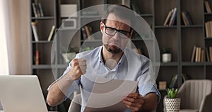 Angry stressed man reading bad news in mail letter document