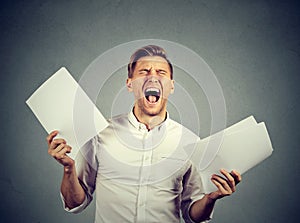 Angry stressed screaming business man with documents papers
