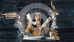 Angry stressed office worker overloaded with paperwork photo