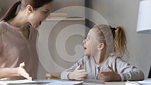 Angry strict young mother arguing with stressed small kid daughter.