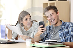 Angry student complaining to slacker classmate at home photo