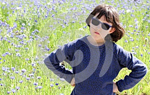 Angry sulking boyish child standing for responsibility statement, beautiful meadow