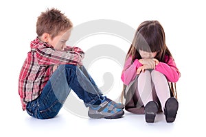 Angry sulking children sitting on the floor