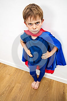 Angry superhero child being irritated by denigrating education, white background photo