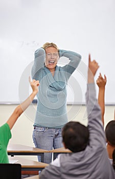 Angry teacher, classroom and shout at kids with raised hand for questions, answer or pop quiz with stress. Teaching