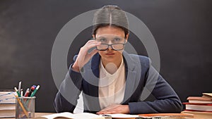 Angry teacher looking aggressively to camera taking off glasses, strict lecturer