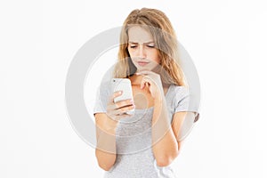 Angry teen woman in grey shirt shouting on smartphone over white background, bad news reading