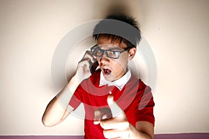 Angry Teenage kid talking on a smartphone and pointing at camera