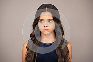 Angry teenager girl, upset and unhappy negative emotion. Little kid girl 12,13, 14 years old on  background