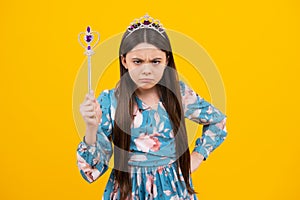 Angry teenager girl, upset and unhappy negative emotion. Portrait of girl princess in tiara holding magic wand. Teenager