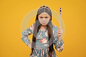 Angry teenager girl, upset and unhappy negative emotion. Portrait of girl princess in tiara holding magic wand. Teenager