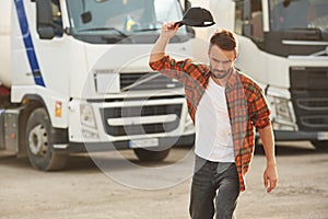 Angry, throwing the cap. Young truck driver in casual clothes