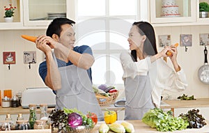 Angry unhappy young Asian woman and man fighting, screaming and gesturing in minimalist kitchen