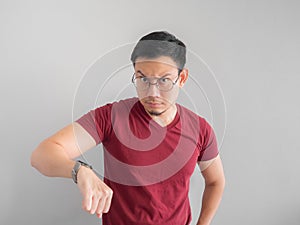 Angry and unpleasant face of man is looking at his watch waiting