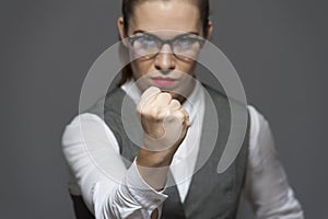 Angry unpleased attractive businesswoman looking at the camera showing fist