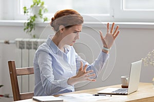 Angry upset businesswoman looking at laptop screen gesturing with irritation