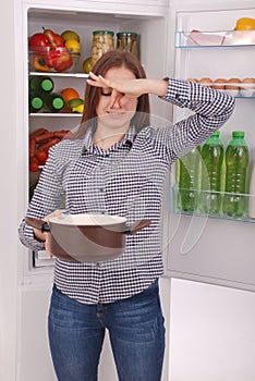 Angry and upset housewife looking into a pot with foul meal