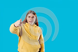 Angry upset woman arguing showing index finger pointing at guilty person punishing mischief in studio, studio portrait