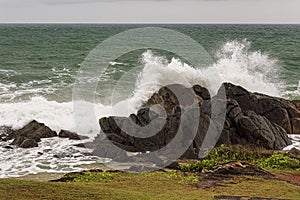 Angry waves crash over rocks on the coast during a summer storm