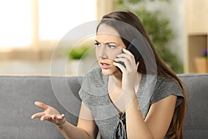 Angry woman arguing during a phone call photo