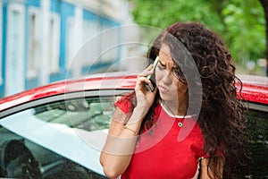 Angry woman calling insurance on phone after car breakdown