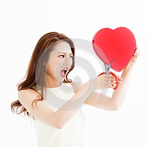 Angry woman cutting the heart shape by scissors