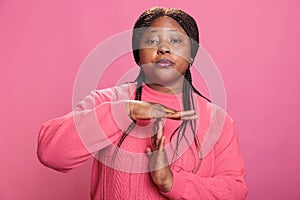 Angry woman doing timeout gesture with t shape hands making break time sign with arms