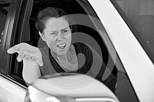 Angry woman driver in a car screaming at traffic conditions