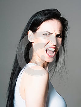 Angry woman face, upset girl. Screaming, hate, rage. Pensive woman feeling furious mad and crazy stress.