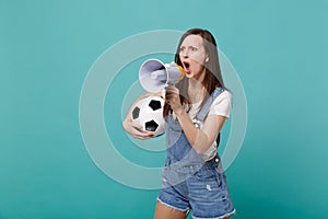 Angry woman football fan scream in megaphone, support favorite team with soccer ball isolated on blue turquoise