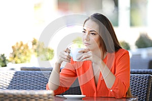 Angry woman holding mug looks away in a coffee shop