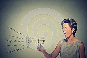 Angry woman holding screaming in megaphone